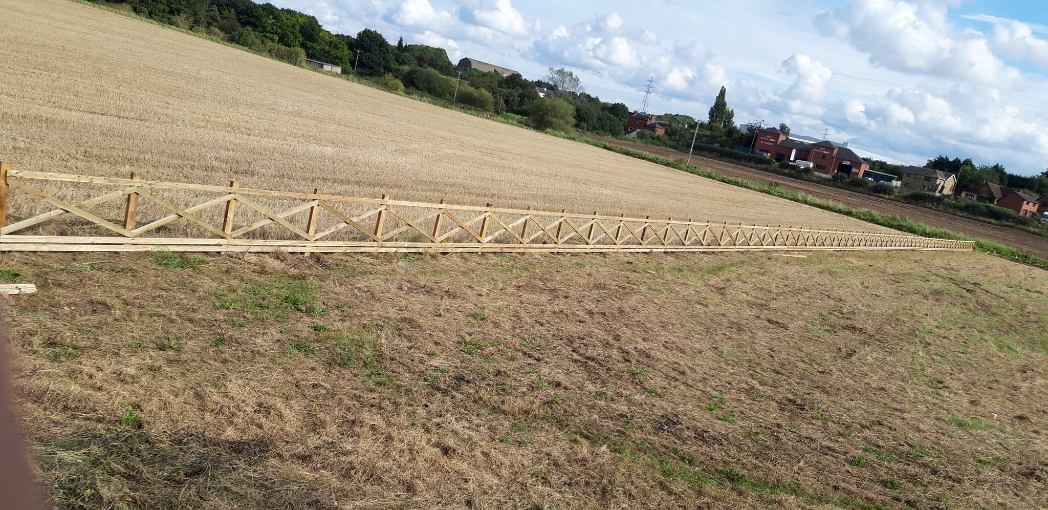 Post and rail fencing installed in a rural field, demonstrating agricultural boundary solutions for landowners and farmers.