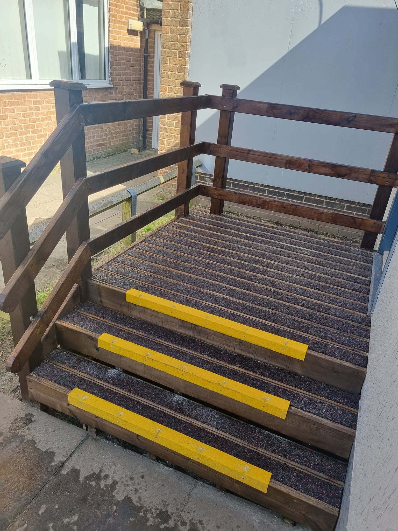 Deck steps featuring pressure-treated timber, anti-slip finishes, and yellow safety strips, designed for safe access in outdoor spaces.