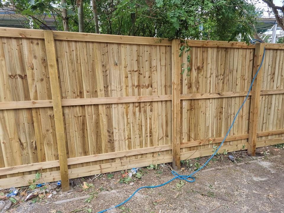 Newly installed wooden garden fencing panels in a residential setting, showcasing a secure and attractive boundary solution.