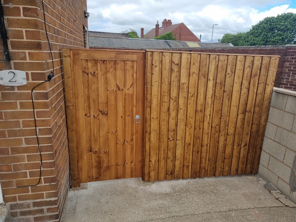 Bespoke wooden pedestrian gate and fence installation at a residential property, highlighting quality craftsmanship and durability for secure access solutions.