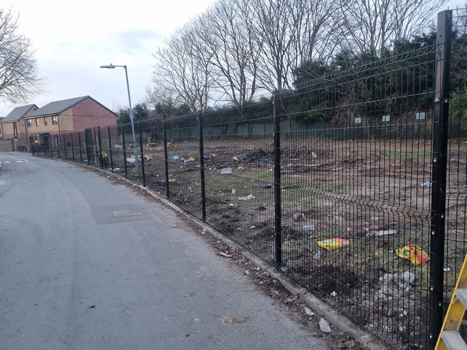 Security fencing installation alongside a residential area, with visible debris in the surrounding ground, highlighting CK Fencing Contractors' capability in providing fencing solutions for site hoarding and perimeter security.