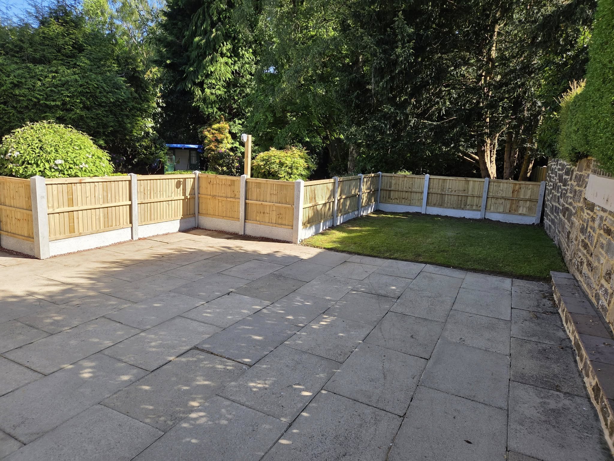Garden area featuring newly installed wooden fencing and a paved patio, showcasing CK Fencing Contractors' quality fencing solutions for secure and attractive outdoor spaces.