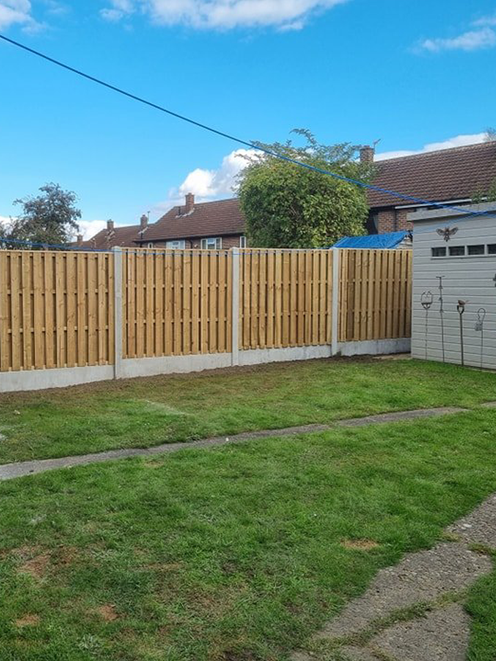 Wooden garden fence providing privacy and security in residential outdoor space, with green lawn and blue sky backdrop, highlighting CK Fencing Contractors' installation services.
