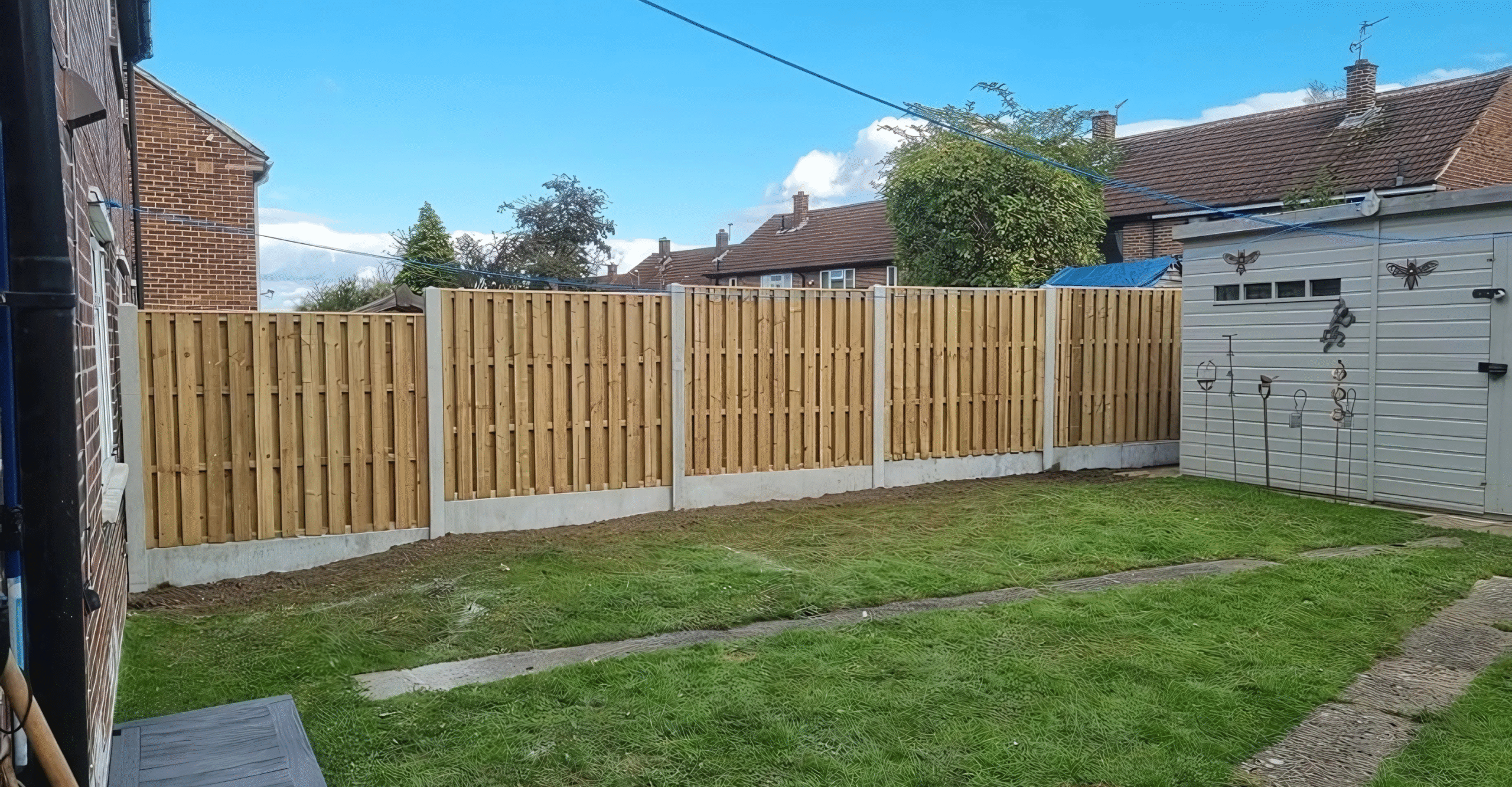 Wooden garden fencing installed in a residential backyard, featuring concrete posts and a well-maintained lawn, showcasing CK Fencing Contractors' quality fencing services in Wakefield.